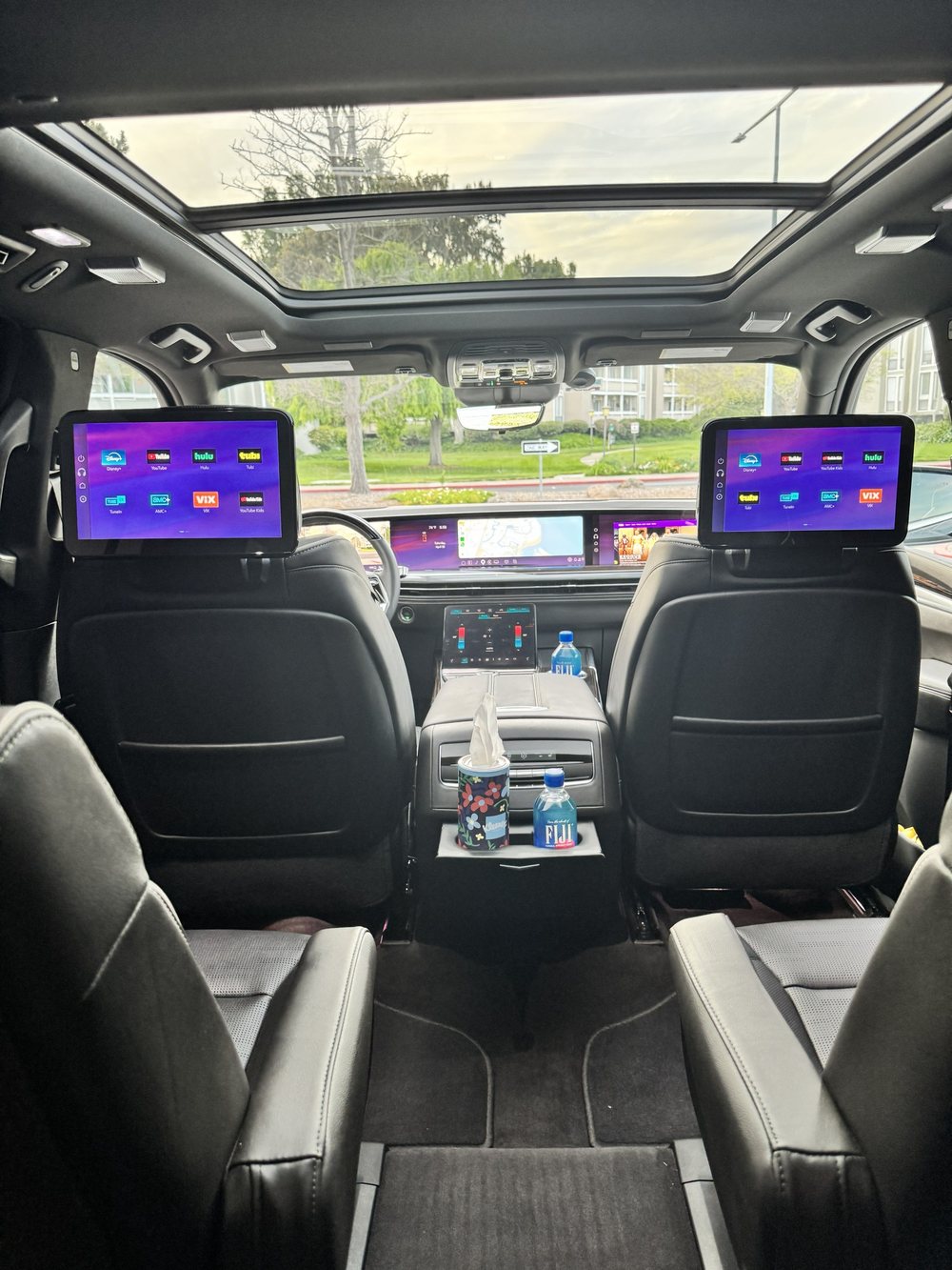 Luxury SUV interior with panoramic sunroof and dual rear entertainment screens — Hayatt Worldwide